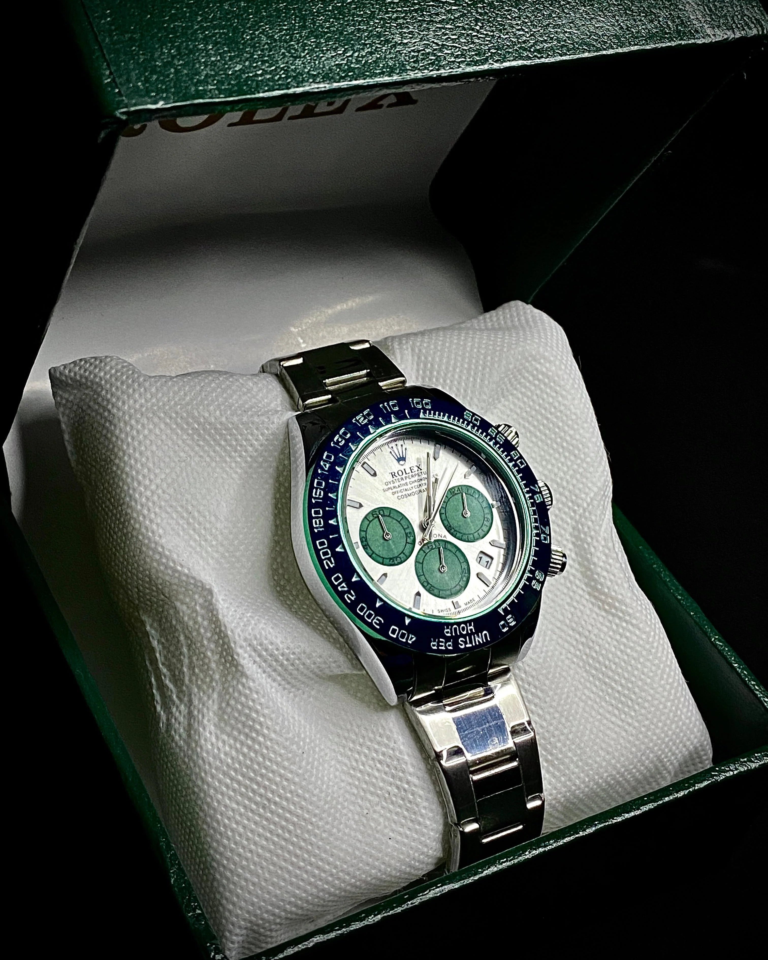Luxury watch with green accents on a white cloth inside a green box